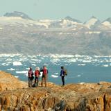 Des randonneurs longent le fjord Sermilik chargé d'icebergs au Groenland Est.