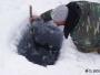 Un habitant des berges du Lac Baïkal a creusé un trou dans la glace pour pêcher. La pêche commerciale est très réglementée ici.